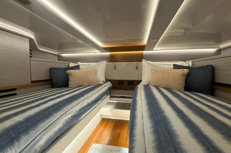 Slide: The Image of Luxurious 2024 Tiara Yachts 48 LS cabin with twin beds and modern lighting. - 17