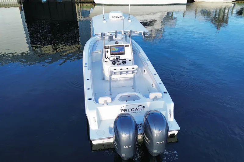 Slide: The Image of 2023 Contender 24 Sport boat with dual Yamaha engines on calm water. - 14