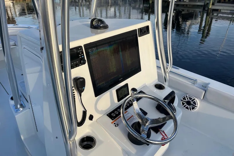 Slide: The Image of 2023 Contender 24 Sport boat console with steering wheel and navigation display. - 16