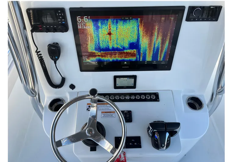 Slide: The Image of 2023 Contender 24 Sport boat dashboard with Garmin display and controls. - 17