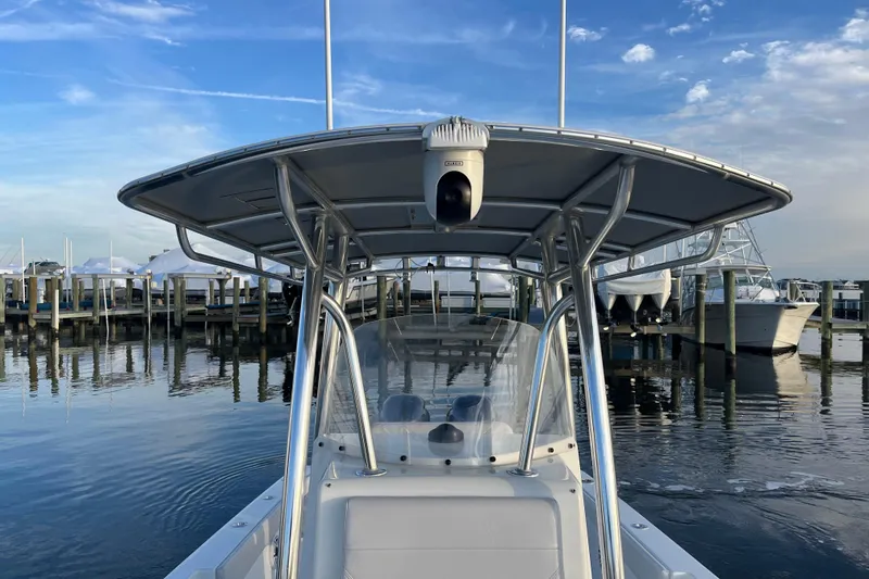 Slide: The Image of 2023 Contender 24 Sport boat docked at marina under clear blue sky. - 19