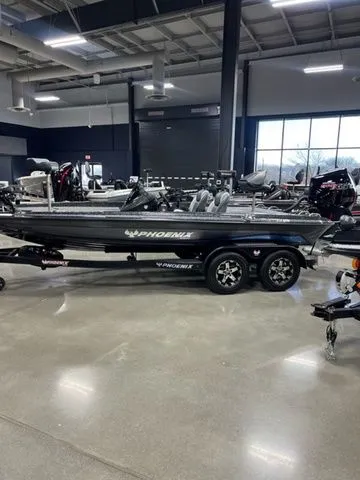 Slide: The Image of 2024 Phoenix Bass Boats 919 Elite in showroom, sleek design, modern features, on trailer. - 2