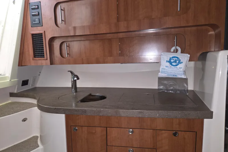 Slide: The Image of 2014 Grady-White Express 370 boat interior with wooden cabinetry and compact sink area. - 12