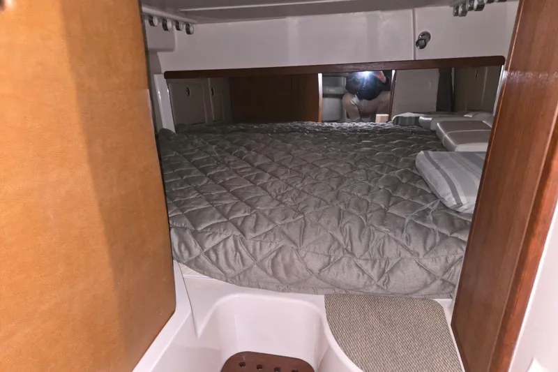 Slide: The Image of 2014 Grady-White Express 370 cabin interior with cozy bed and wooden accents. - 14