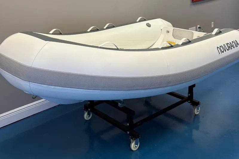 Slide: The Image of 2025 Novurania TR 270 inflatable boat displayed indoors with contact information sign. - 4
