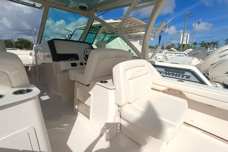 Slide: The Image of 2026 Grady-White Freedom 325 boat interior with helm and seating under clear sky. - 17