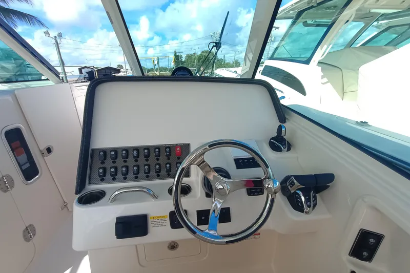 Slide: The Image of 2026 Grady-White Freedom 325 boat helm with steering wheel and control panel. - 19