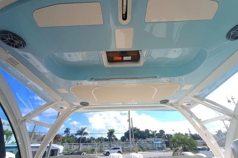 Slide: The Image of 2026 Grady-White Freedom 325 boat interior ceiling with speakers and hatch, under clear sky. - 22