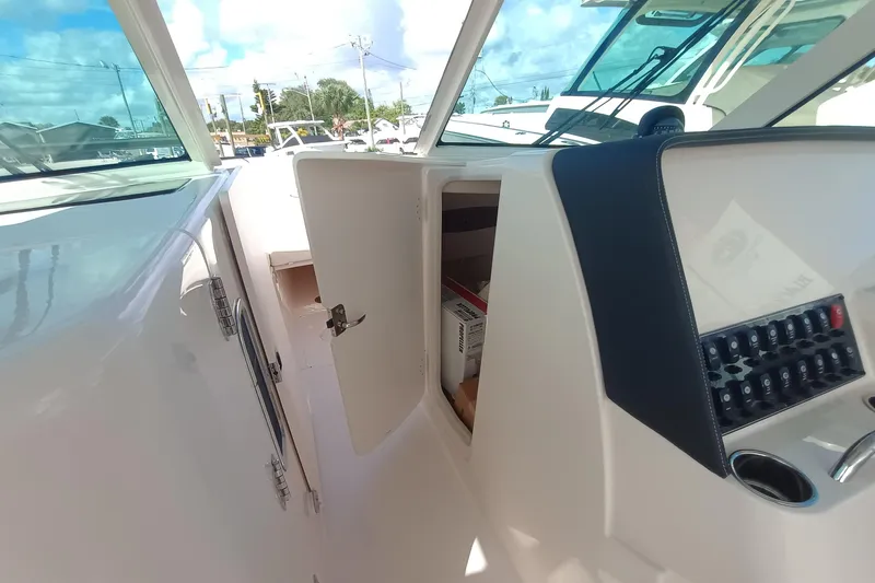 Slide: The Image of 2026 Grady-White Freedom 325 boat interior with open storage compartment and control panel. - 23