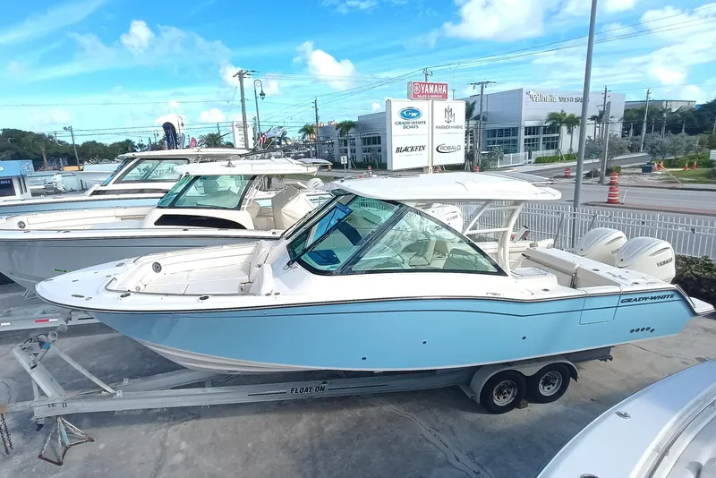 Slide: The Image of 2026 Grady-White Freedom 325 boat on trailer at dealership, clear sky background. - 8