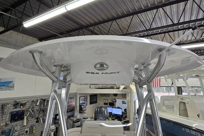 Slide: The Image of 2026 Sea Hunt Ultra 219 boat interior with T-top in showroom setting. - 13