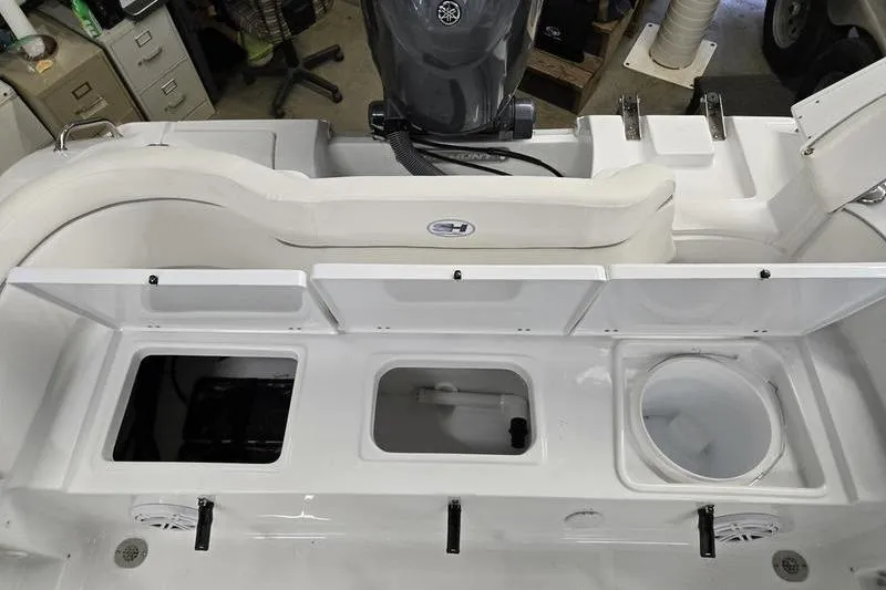 Slide: The Image of 2026 Sea Hunt Ultra 219 boat interior with open storage compartments and Yamaha engine. - 19
