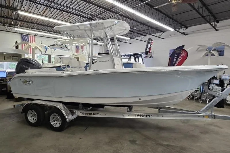 The Image of 2026 Sea Hunt Ultra 219 boat on trailer in showroom, side view. - 3