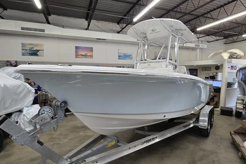 Slide: The Image of 2026 Sea Hunt Ultra 219 boat on trailer in showroom, under bright lighting. - 4