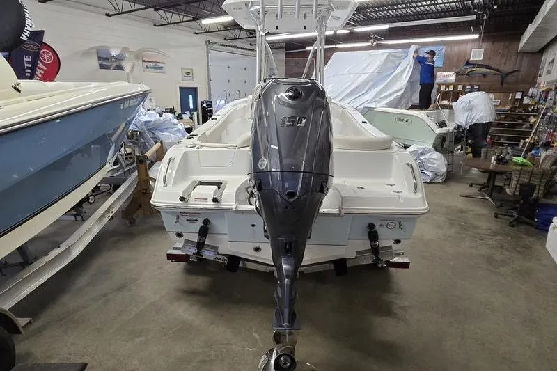 Slide: The Image of 2026 Sea Hunt Ultra 219 boat with outboard motor in a showroom. - 5