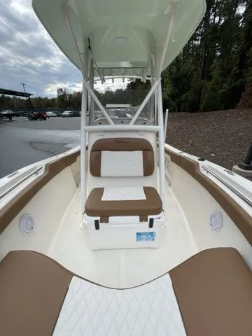 Slide: The Image of 2024 Pioneer Sportfish 202 boat interior with cushioned seating and overhead canopy. - 10