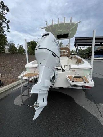Slide: The Image of 2024 Pioneer Sportfish 202 boat with outboard motor, rear view, parked on pavement. - 3