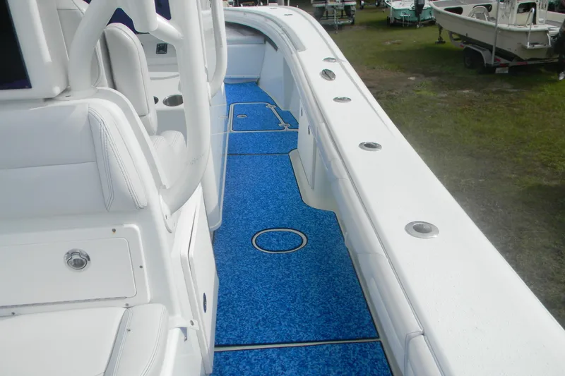 Slide: The Image of 2017 Yellowfin 32 Offshore boat interior with blue flooring and white seating. - 10