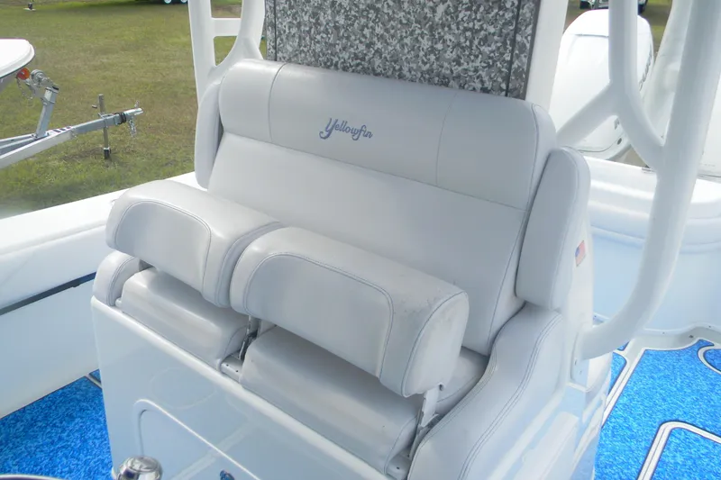 Slide: The Image of 2017 Yellowfin 32 Offshore boat seat with white upholstery and blue flooring. - 14