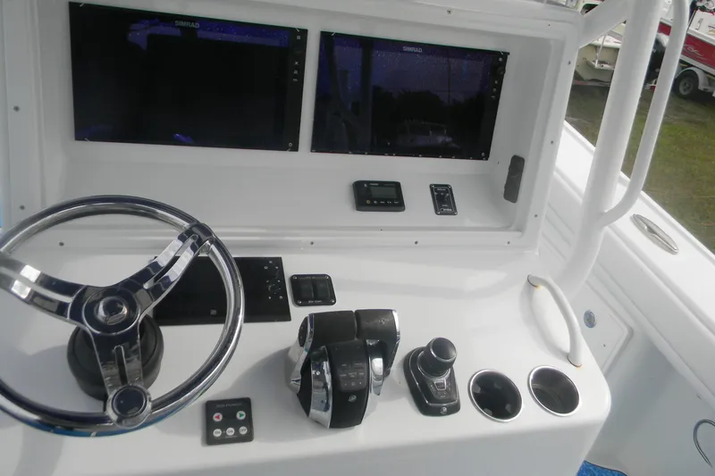 Slide: The Image of 2017 Yellowfin 32 Offshore boat dashboard with steering wheel and electronic controls. - 15