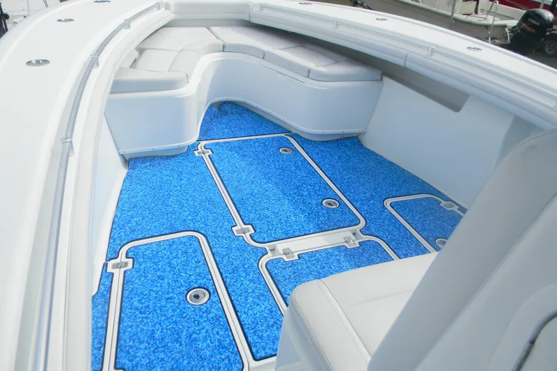 Slide: The Image of 2017 Yellowfin 32 Offshore boat interior with blue flooring and cushioned seating. - 16