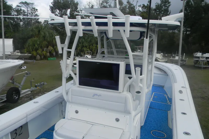 Slide: The Image of 2017 Yellowfin 32 Offshore boat with blue deck, rod holders, and console display. - 5