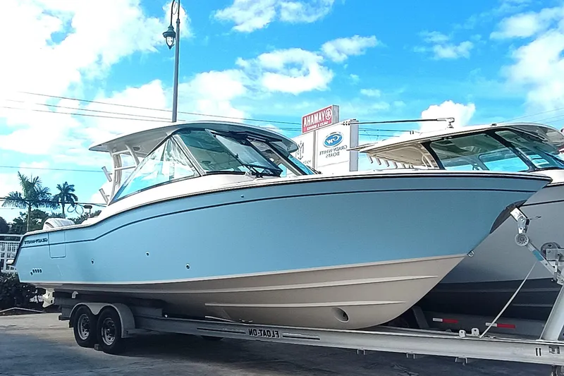 The Image of 2026 Grady-White Freedom 325 boat on trailer under clear blue sky. - 1