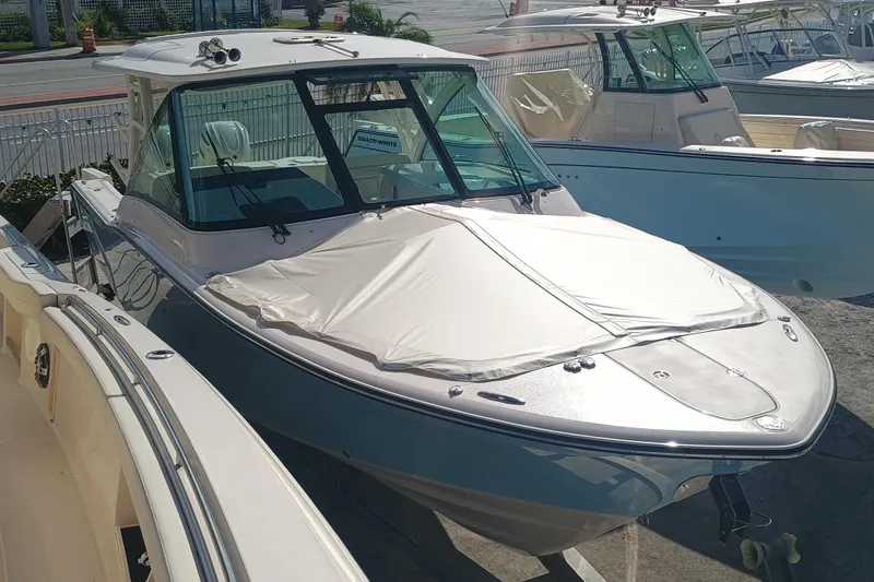 Slide: The Image of 2026 Grady-White Freedom 325 boat displayed outdoors, covered and docked. - 13