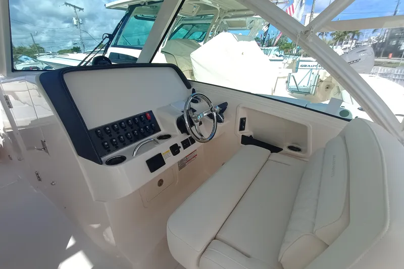 Slide: The Image of 2026 Grady-White Freedom 325 boat interior with steering wheel and control panel. - 19