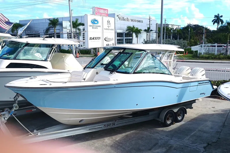 Slide: The Image of 2026 Grady-White Freedom 325 boat on trailer at dealership, sunny day. - 3