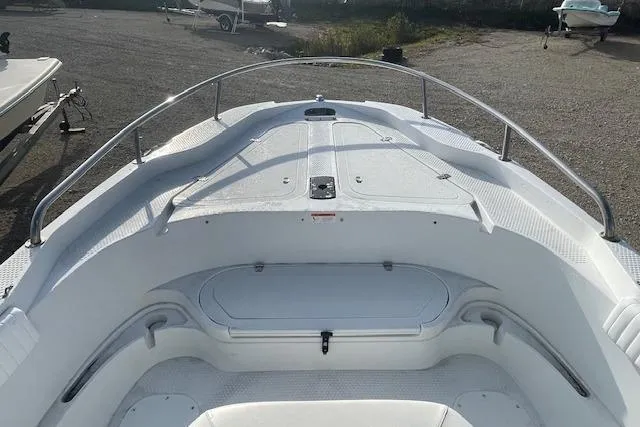 Slide: The Image of 2011 Triumph 190 Bay boat, white deck, stainless steel railings, parked on gravel. - 12