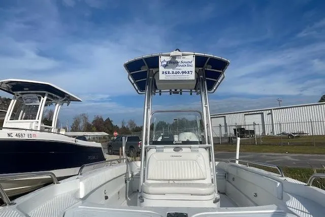 Slide: The Image of 2011 Triumph 190 Bay boat with T-top, parked outdoors under a clear blue sky. - 15