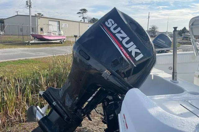 Slide: The Image of 2011 Triumph 190 Bay boat with Suzuki outboard motor, parked outdoors. - 19