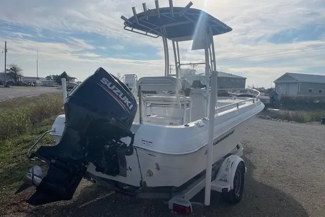 Slide: The Image of 2011 Triumph 190 Bay boat with Suzuki outboard motor on trailer, parked outdoors. - 3