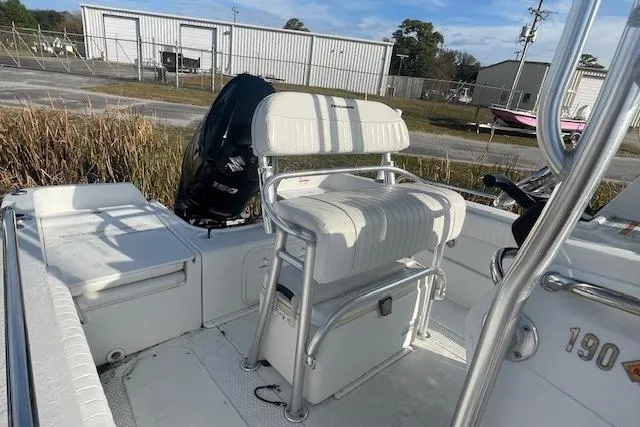 Slide: The Image of 2011 Triumph 190 Bay boat interior with seating and motor, parked outdoors. - 4