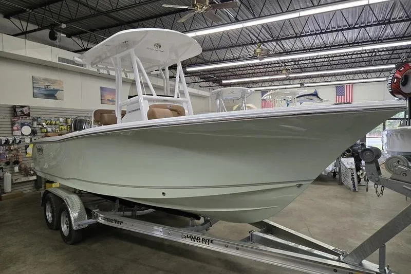 The Image of 2025 Sea Hunt Ultra 229 boat displayed indoors on a trailer. - 1