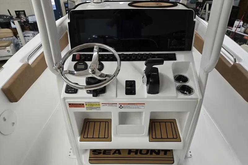 Slide: The Image of 2025 Sea Hunt Ultra 229 boat console with steering wheel and controls. - 11