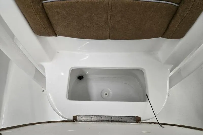 Slide: The Image of 2025 Sea Hunt Ultra 229 boat interior with storage compartment and cushioned seating. - 17