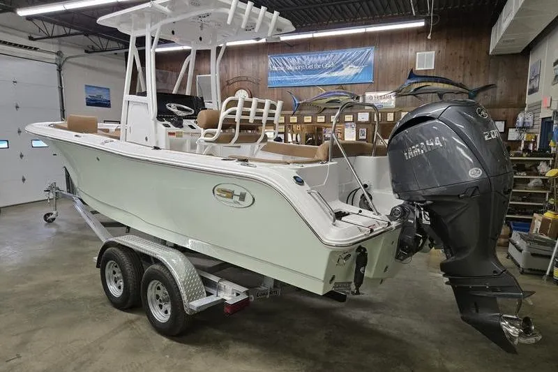 Slide: The Image of 2025 Sea Hunt Ultra 229 boat on trailer in showroom with Yamaha outboard motor. - 4