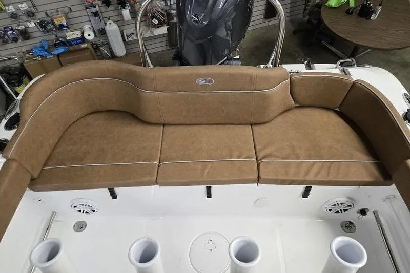 Slide: The Image of 2025 Sea Hunt Ultra 229 boat with tan cushioned seating and rod holders. - 5