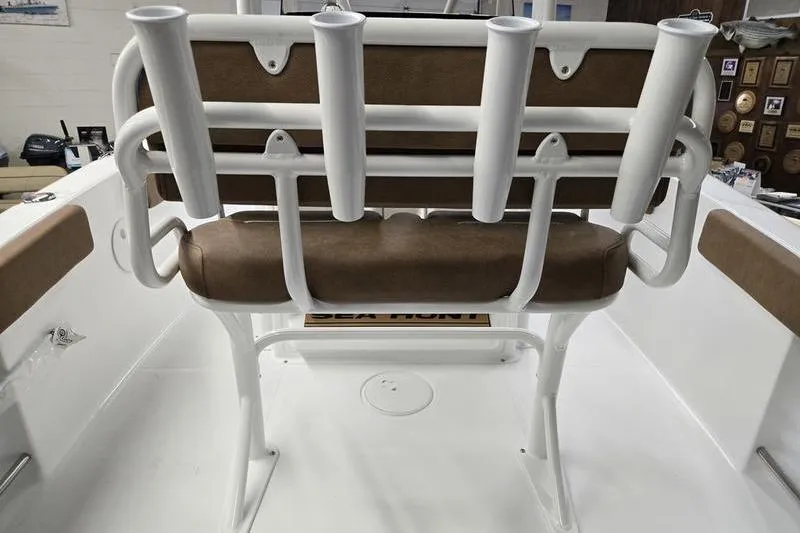 Slide: The Image of 2025 Sea Hunt Ultra 229 boat seat with rod holders, brown cushions, and white frame. - 7