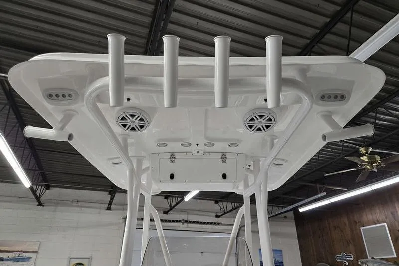 Slide: The Image of 2025 Sea Hunt Ultra 229 boat top view with rod holders and speakers in a showroom. - 8