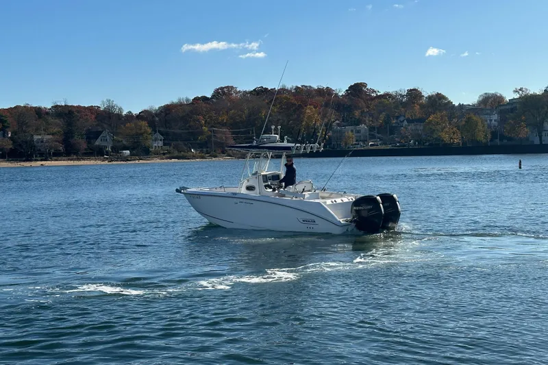 Slide: The Image of 2006 Boston Whaler 240 Outrage boat cruising on a calm lake with autumn trees. - 2