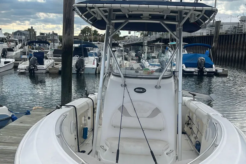 Slide: The Image of 2006 Boston Whaler 240 Outrage docked at marina, surrounded by other boats. - 21