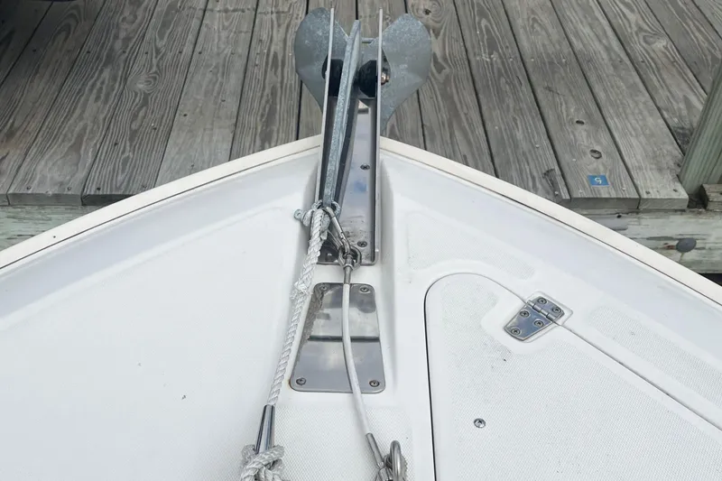 Slide: The Image of Bow of 2006 Boston Whaler 240 Outrage with anchor and rope, docked on wooden pier. - 22
