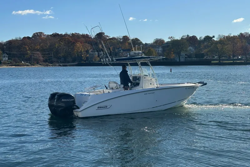 Slide: The Image of 2006 Boston Whaler 240 Outrage boat cruising on a calm lake with autumn trees. - 3