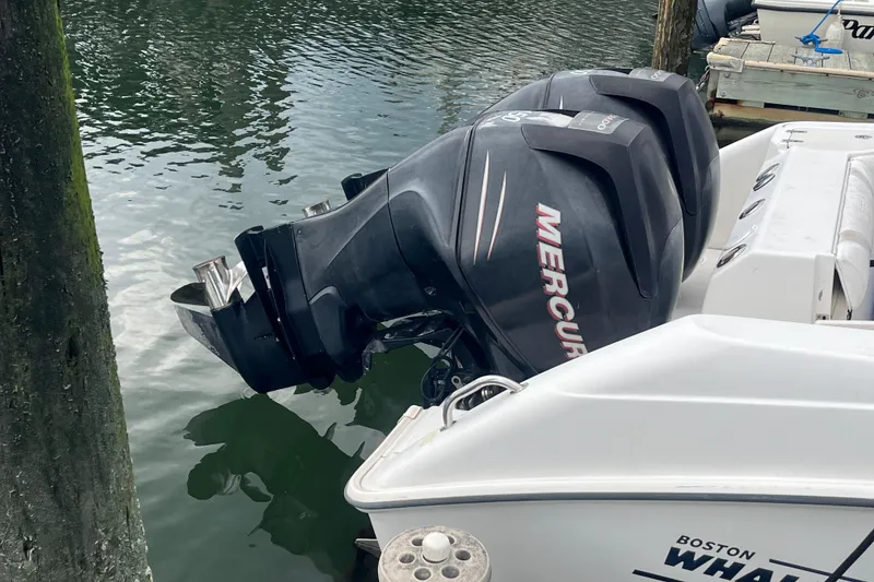 Slide: The Image of 2006 Boston Whaler 240 Outrage with dual Mercury outboard engines docked by water. - 6