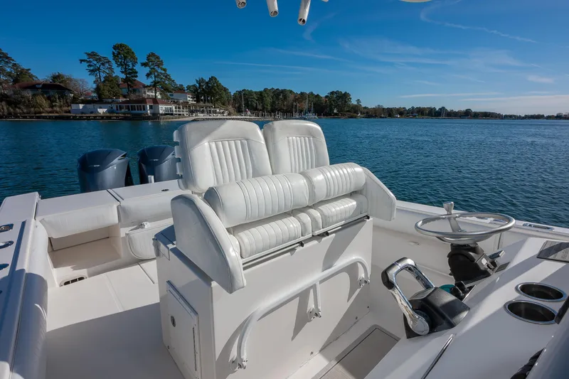 Slide: The Image of 2008 Regulator 32 Forward Seating boat on calm water, featuring dual engines and white seating. - 16