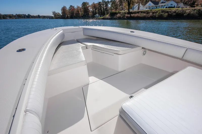 Slide: The Image of 2008 Regulator 32 Forward Seating boat interior with white cushioned seats on a calm lake. - 18