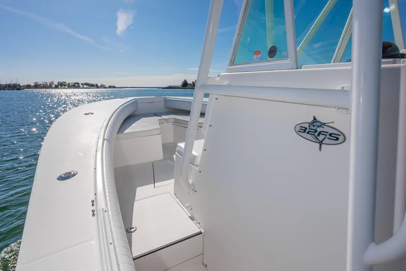 Slide: The Image of 2008 Regulator 32 Forward Seating boat on sunny water, showcasing sleek design and spacious deck. - 19